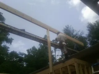 Carpenter setting a ridge beam over a new addition frame — Ice Dam Removal by Roofing Brothers in Preston Park