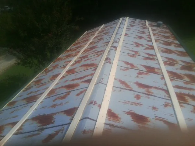 Rusted metal roof panels with new wood purlins before replacement — Storm Damage Roof Repair in Preston Park by Roofing Brothers