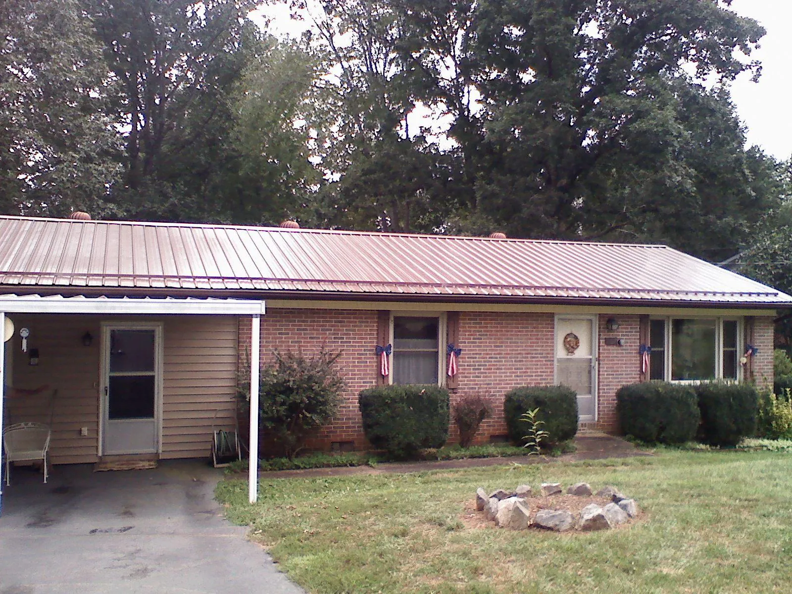 Bronze metal roof and carport on a brick ranch home — Roof Repair work by our crew in Preston Park