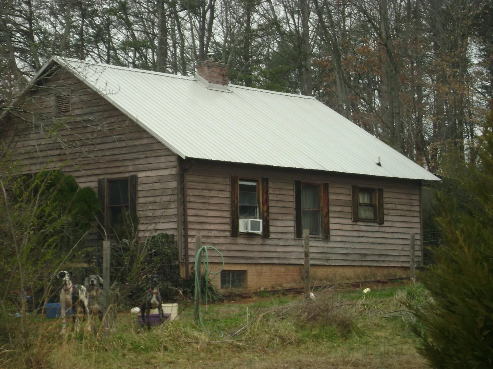White metal roof on an old wood sided farmhouse, from a Metal Roof Installation job in Preston Park